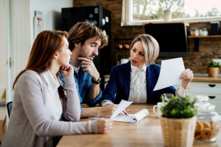 Insurance Agent Talking To A Couple About Terms Of Their Lease A